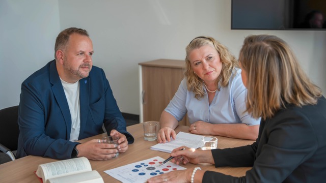 Ein Mann und zwei Frauen am Tisch im Gespräch