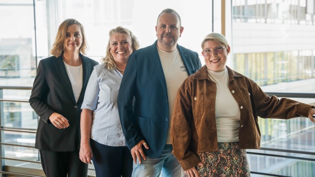 Ein Mann und drei Frauen stehend in einer Reihe