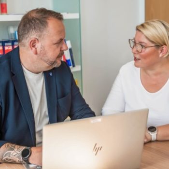 zwei Personen im Büro mit Laptop
