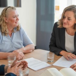 Drei Personen im Gespräch an einem Tisch